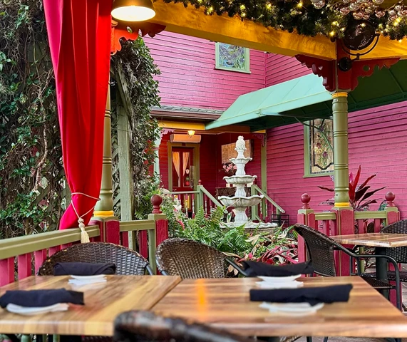 Rose Villa's shaded courtyard dining area with a fountain and colorful historic details.